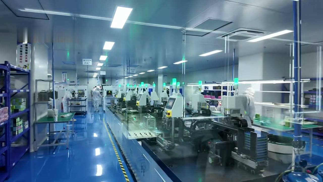 Cleanroom assembly line with operators in gowns at active-alignment stations